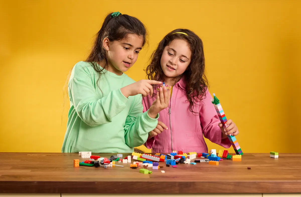 Image of two children playing with LEGO bricks on a countertop table - Virginia